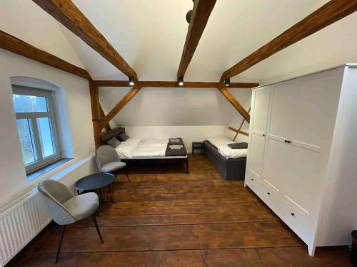 a bedroom with a bed and chairs in a room at Vila 100klasa in Nejdek