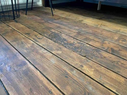 a wooden floor with a chair sitting on top of it at Vila 100klasa in Nejdek