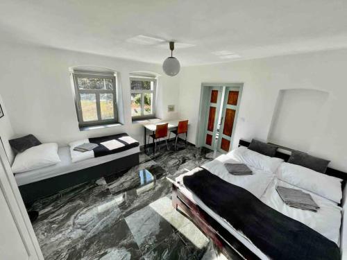 a bedroom with two beds and a table in it at Vila 100klasa in Nejdek