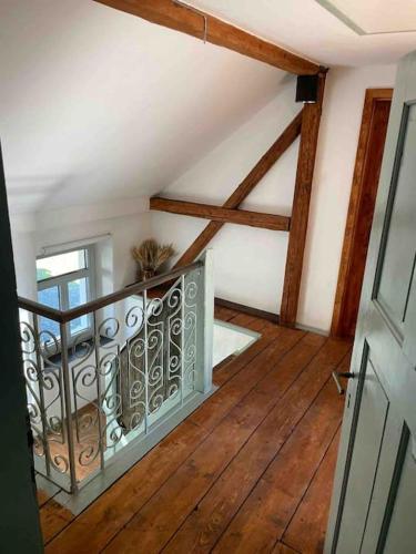 an attic room with a metal railing on a wooden floor at Vila 100klasa in Nejdek