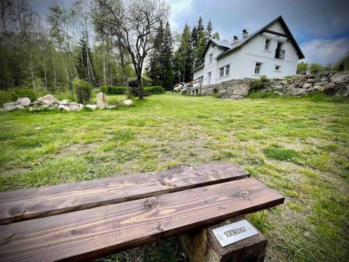 a bench sitting in a field in front of a house at Vila 100klasa in Nejdek