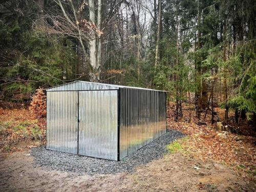 a metal gate in the middle of a forest at Vila 100klasa in Nejdek