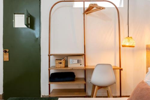 a room with a desk with a chair and a mirror at Botánica Casa Hotel in Medellín