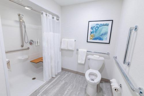 a white bathroom with a toilet and a shower at Hilton Garden Inn Lakewood in Lakewood