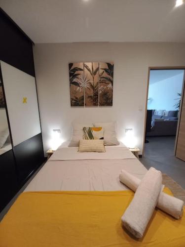a bedroom with a large bed with a yellow blanket on it at Villa avec piscine in Gaujac