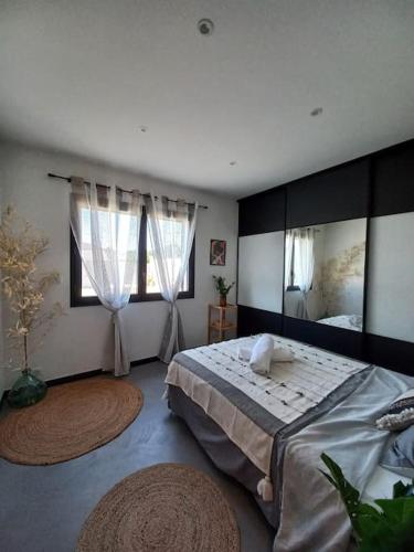 a bedroom with a large bed and two windows at Villa avec piscine in Gaujac