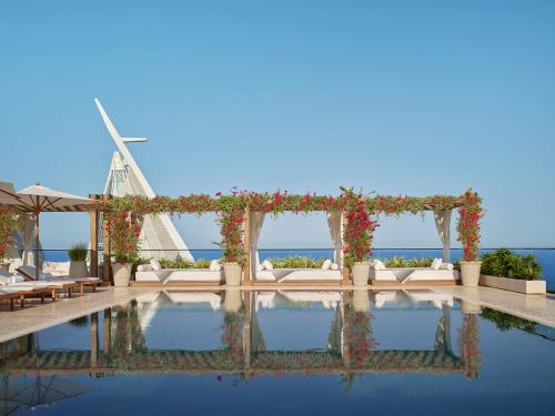 a wedding ceremony arch with a windmill in the background at The Jeddah EDITION in Jeddah