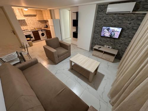a living room with a couch and a table and a tv at Kyrenia center, 2 bedroom, 1 living room, residential apartment in Kérynia