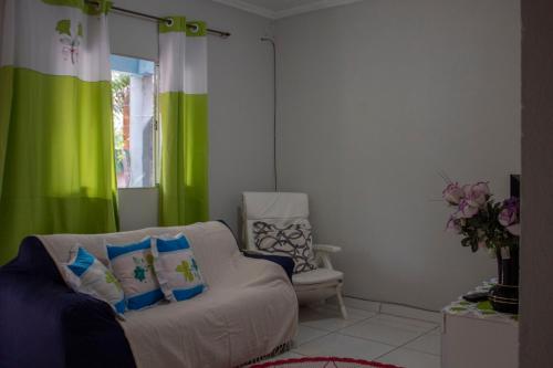 a living room with a couch and a green curtain at Casa c Wi-Fi a 10min do centro historico de Paraty in Trindade