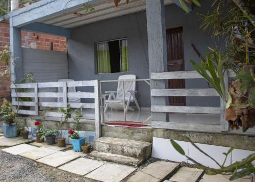 a house with a fence and a chair in front of it at Casa c Wi-Fi a 10min do centro historico de Paraty in Trindade