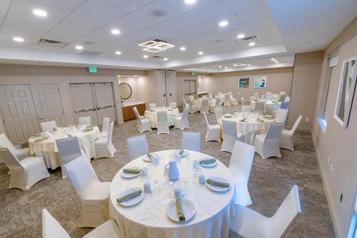 a banquet room with white tables and white chairs at Hilton Garden Inn Lakewood in Lakewood