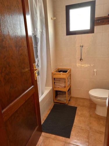 a bathroom with a toilet and a shower and a door at Vv Maruja in Arrieta