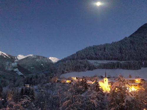 a view of a town in the mountains at night at Chalet Serein in Seytroux