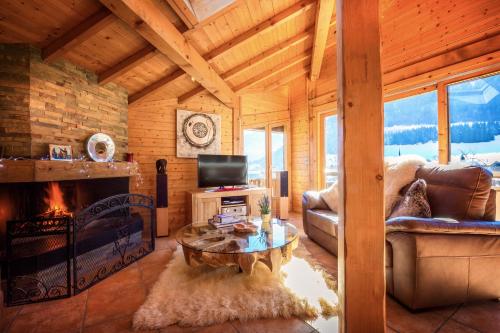a living room with a fireplace in a log cabin at Chalet Serein in Seytroux