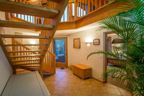 a wooden spiral staircase in a room with a plant at Chalet Serein in Seytroux