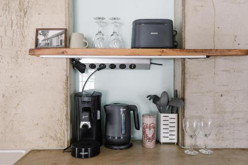 a shelf with a coffee maker and wine glasses at Alte Schreinerei in Monschau