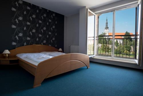 - une chambre avec un lit et une grande fenêtre dans l'établissement Hotel Diana, à Nové Mesto nad Váhom
