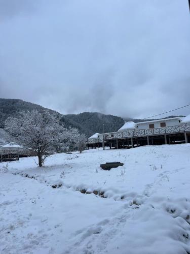 a building in a field covered in snow at Ethno complex Ala kuch in Kaindy