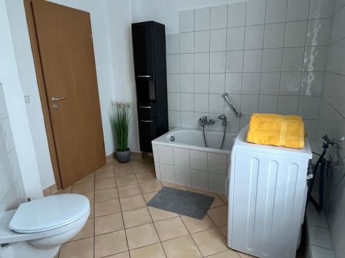 a bathroom with a toilet and a tub and a sink at Apartment mit Balkon & Parkplatz in Meißen