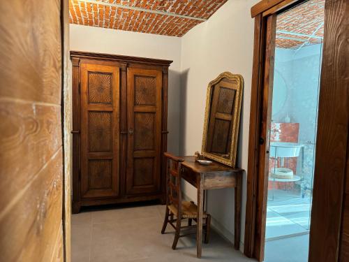 a room with a mirror and a wooden cabinet at Le Relais du Bourg Chambres de charme Wellnes in Donnas