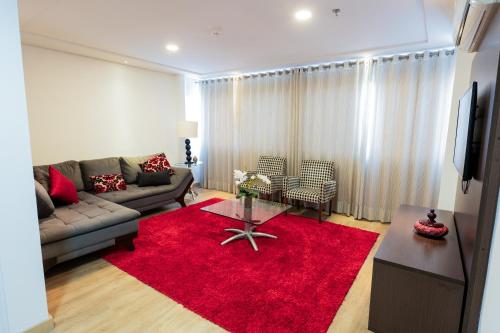 a living room with a couch and a red rug at Olavo Bilac Hotel in Taubaté