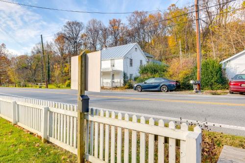 a white fence and a car on a street at Historical Thurmont Escape with Furnished Deck! in Thurmont