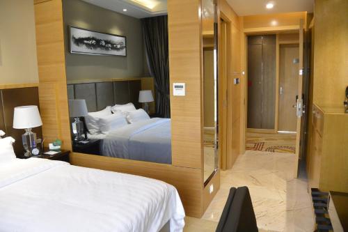 a hotel room with a bed and a sliding glass door at Hotel Anda China Malabo in Malabo