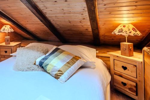 une chambre avec un lit avec un oreiller dessus dans l'établissement Slow Chalet Etale Ski in-out Duplex Mountain View Balcony & Free parking, à Manigod