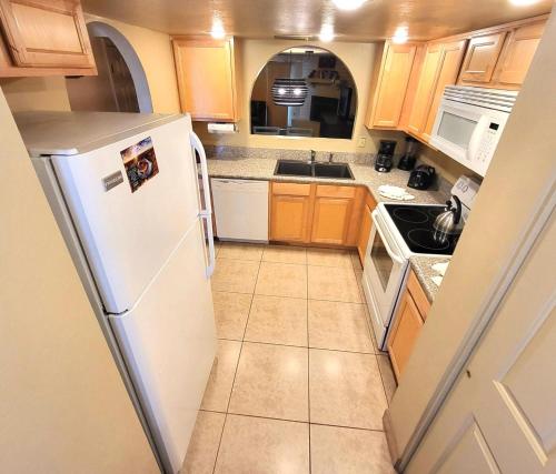 a kitchen with a white refrigerator and wooden cabinets at Villas of Sedona in Sedona