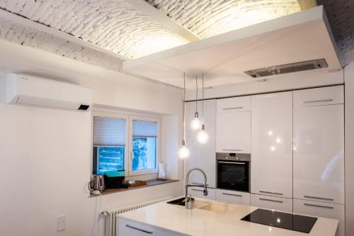 cocina con armarios blancos y techo en Simon's House, en Trieste