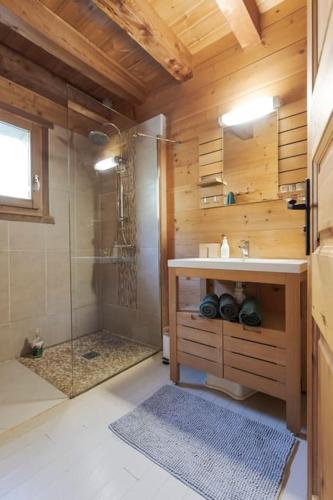 La salle de bains est pourvue d'une douche, d'un lavabo et d'une douche en verre. dans l'établissement Chalet Veyrier, 900m du pied des pistes de ski, à Abriès