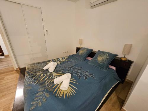 a bedroom with a bed with slippers on it at Sur les toits in Draguignan