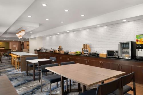 a restaurant with tables and chairs and a counter at Fairfield Inn & Suites Naperville/Aurora in Naperville