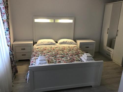 a bedroom with a bed with a flowery bedspread at Agropa Rooms & Garden Events in Bistriţa