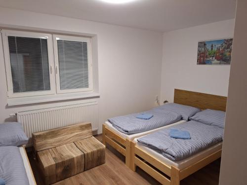 a bedroom with two twin beds and a window at BUBO Penzion & Restaurant in Moravany