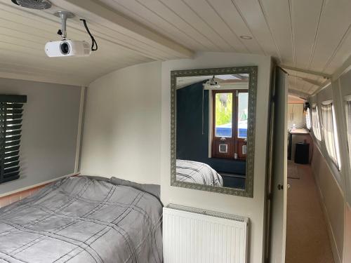a small bedroom with a bed and a mirror at The Boat in Skipton