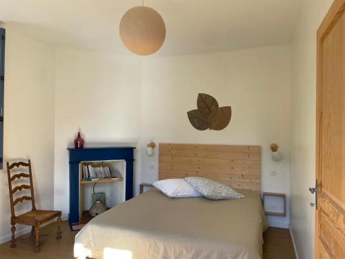 ソミュールにあるChez Juliette - Maison et jardin - bord de Loire à Saumurのベッドと椅子のある寝室