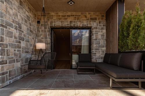 a porch with a couch and a swing at Jaggling Appartements in Sankt Ulrich am Pillersee