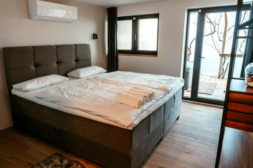 a large bed in a room with a large window at Cozy Home - Klet Matija in Novi Marof