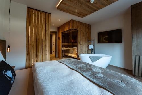 a bedroom with a large bed and a bath tub at Jaggling Appartements in Sankt Ulrich am Pillersee