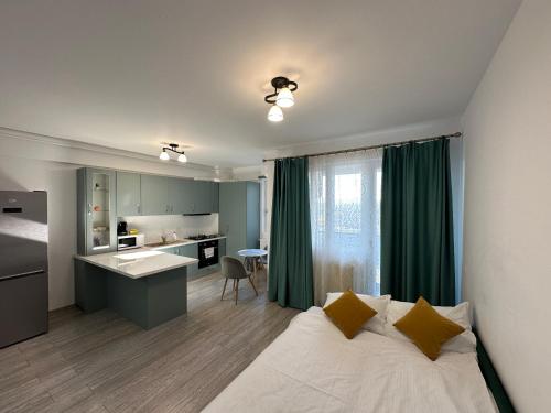 a bedroom with a bed and a kitchen with green curtains at Renting Solutions Q in Iaşi