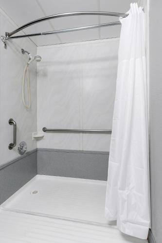 a shower with a white shower curtain in a bathroom at Hotel Seward in Seward