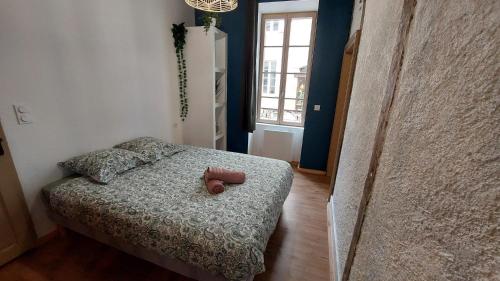 une chambre avec un lit avec un ours en peluche dessus dans l'établissement Coeur de Ville N1, à Montluçon