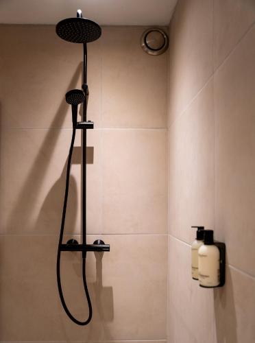 a bathroom with a shower with a bottle of soap at Skinny Bridge Boutique Stay in Amsterdam