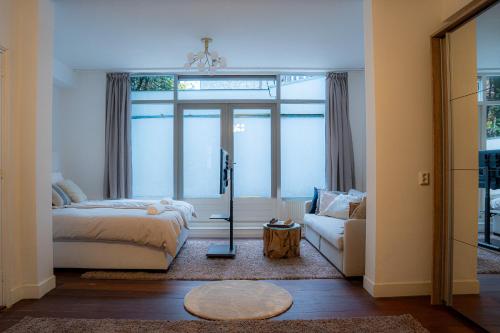 a bedroom with a bed and a couch at Skinny Bridge Boutique Stay in Amsterdam