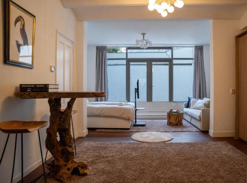 a living room with a bed and a table at Skinny Bridge Boutique Stay in Amsterdam