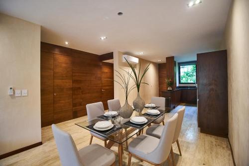 a dining room with a table and white chairs at Aldea Zama Hideaway with Private Pool in Gated Community in Tulum