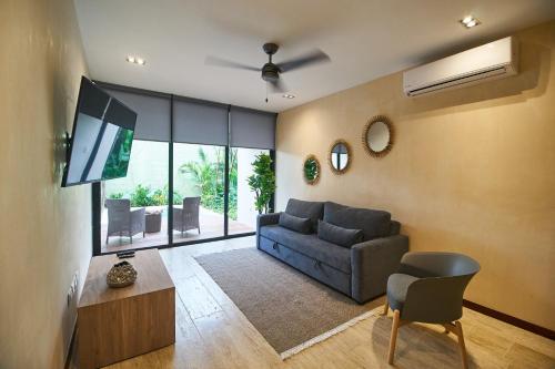 a living room with a couch and a tv at Aldea Zama Hideaway with Private Pool in Gated Community in Tulum