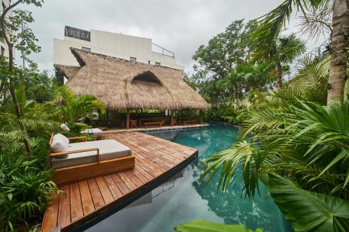 a resort with a pool and a thatched building at Aldea Zama Hideaway with Private Pool in Gated Community in Tulum