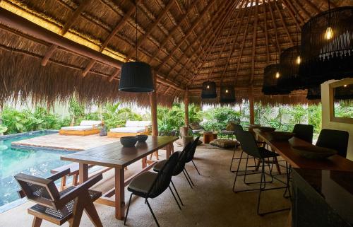 a dining room with a table and chairs and a pool at Aldea Zama Hideaway with Private Pool in Gated Community in Tulum